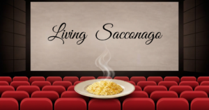 Schermo cinematografico con la scritta Living Sacconago e un piatto di risotto fumante in primo piano sulle poltrone rosse.